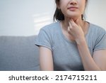 Small photo of Young Asian woman have a sore throat cough symptom and feel sick from virus or bacteria infection influenza by touching her neck and hard to swallow