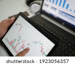 Businessman checking stock market dataมStock Market Application for Mobile, Analyzing Data Stock Market on Mobile Young Businessman with Smartphone and Stock Market Chart Background.