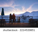 Gudauri, Georgia - 14th february, 2022: Couple together sit enjoy sunset in winter ski resort with snowy peaks background. Valentines day in winter concept. Togetherness connection concept