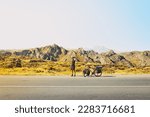 Cinematic travel inspirational panorama caucasian traveler cyclist stand on road take smiley self-portrait with mobile phone. Solo travel bicycle touring around the world