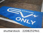 EV station sign on cement ground, reservation for electric car parking lot. Sign and symbol technology object, selective focus.