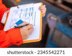 Small photo of Action of a supervisor is using a pen to writing on chemical hazardous material paper form to rating the risk. Industrial safety working. Selective focus.
