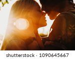 Close up portrait of a beautiful young couple waiting to kiss in their traveling time against sunset light.