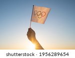 The olympic flag  small in hand ...