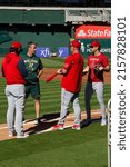 Small photo of Oakland, California - May 18, 2022: Los Angeles Angels coaches Jeremy Reed and Phil Nevin and infielder Tyler Wade talk with Oakland Athletics bench coach Brad Ausmus talk at the Oakland Coliseum.