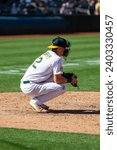 Small photo of Oakland, California - August 21, 2022: Oakland Athletics catcher Sean Murphy warms up the pitcher between innings of a game against the Seattle Mariners at the Oakland Coliseum.