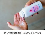 Small photo of August 25, 2022, Brazil. In this photo illustration, a person uses Johnson Johnson baby powder on their hands. The company will suspend the sale of the product from 2023