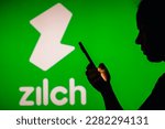 Small photo of March 31, 2023, Brazil. In this photo illustration, a woman's silhouette holds a smartphone with the Zilch logo in the background