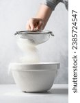 Woman's hand sifting flour into ...