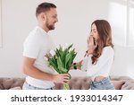 Celebrating Special Occasion. Giving girl a bouquet of colorful wilted tulips. Man greeting lady with international women's day. Couple separation, betrayed, misunderstood wife. 