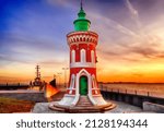 Small photo of the historical lighthouse "Kaiserschleuse Ostfeuer" (Pingelturm) in Bremerhaven, Germany in front of colorful kitschy sunset sky