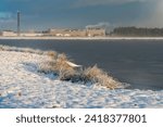 Small photo of Brake, Germany - January 18, 2024: the factory Rehau seen behind the biotope Kleiputte during a sunny and snowy winter morning
