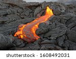 Small photo of Hot magma of an active lava flow emerges from a rock fissure, the glowing lava makes the air flicker with heat, the lava cools down slowly and solidifies in bizarre patterns - Hawaii, Big Island
