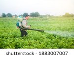 A Farmer With A Mist Sprayer...