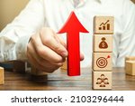 Small photo of Businessman holds an up arrow near business attributes. Expansion of business company. Using new approaches and tools. Development of leadership organizational skills. Entrepreneurship management.
