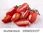 Small photo of bunch of freshly picked San Marzano tomatoes laid down on a light wooden table