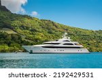 Small photo of Large sixty meter Motor Yacht, Superyacht at anchor in Cook's Bay in tropical island of Moorea, French Polynesia. With verdant green landscape in the background