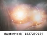 Glittering light shine through hand women,who raise hands,to pray for God blessing,planet and sunset background mind sanctification,concept pure spirit and spirituality,Element image furnished by NASA