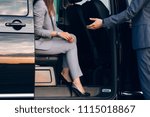 Business woman travelling in vip car transfer. Driver helping woman to get outside the car. Gentleman give a hand to the lady at the car