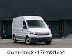Delivery van near a warehouse at logistic park. Modern minivan ready for loading. Cargo and storage HUB near the city. Lorry truck at the industrial entrepot. Courier and express delivery service 