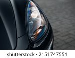 The headlight of the modern luxury car close up. The front side of a clean black SUV car. 