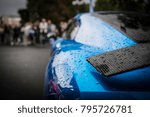 Raindrops on supercar carbon wing spoiler. Coupe car at the contest 