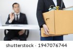 Small photo of Young woman wearing a black suit raises a brown cardboard box from the office, Businessmen pack personal belongings and equipment after Resign or being fired, Employment contract is expire.