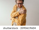 Small photo of Aching frozen shoulder pain as symptom of rotator cuff tendinitis, adult caucasian male with painful grimace suffering from chronic bursitis