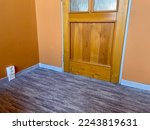 Small photo of Carpet with plastic baseboard with a wooden texture. Newly installed wooden grey carpet flooring and baseboards in home. Modern design. Close-up of plastic plinths and caramel wall. High quality photo