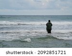 A Lone Fisherman Standing Knee...
