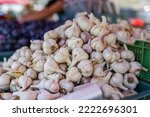 Packs of garlic bulbs with purple stripes on display at local food market, closeup detail