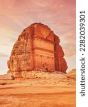 Small photo of Tomb Lihyan Son of Kuza, Lonely Castle or Qasr al-Farid at Hegra, Saudia Arabia - most popular landmark in Mada'in Salih archaeological site, sandy desert landscape around - toned in orange pink color