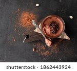Vegan chocolate mousse glass on a wooden board with a spoon on a dark background. Top view. Flat lay