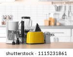 Household and kitchen appliances on table against blurred background