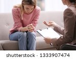 Psychotherapist working with young woman in light office