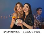 Beautiful young women with martini cocktails in bar