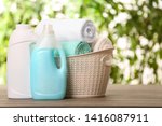 Basket with clean towels and detergents on table against blurred background. Space for text