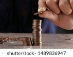 Man Stacking Coins On Brown...