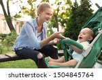 Teen nanny with cute baby in stroller playing in park