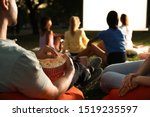 Young people with popcorn watching movie in open air cinema, closeup. Space for text