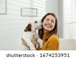 Young woman with her cute Jack Russell Terrier at home. Lovely pet