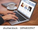 Young woman visiting online dating site via laptop at table, closeup