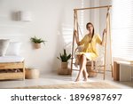 Beautiful woman resting in hammock chair at home