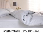Comfortable bed with soft blanket indoors, closeup