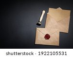 Envelopes with wax seal and stamp on black background, flat lay. Space for text