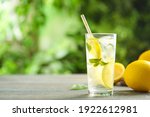 Cool freshly made lemonade and fruits on grey wooden table. Space for text