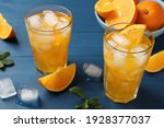 Delicious orange soda water on blue wooden table