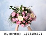 Woman with bouquet of beautiful roses on light blue background, closeup