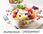 Delicious fruit salad with yogurt on light table