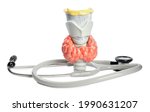 Small photo of Plastic model of afflicted thyroid and stethoscope on white background